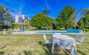 a table and chairs in front of a house at Manoir du Village in Irais