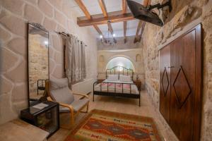 a bedroom with a bed and a chair in a room at Corner İn Cappadocia in Ortahisar