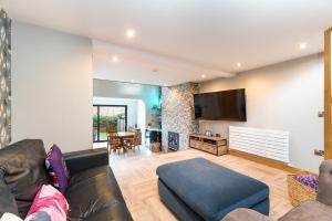 a living room with a couch and a tv at The Grand Weave House in Shipley