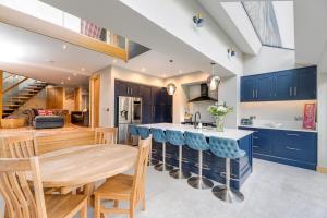 a kitchen with a wooden table and blue cabinets at The Grand Weave House in Shipley
