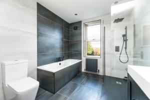 a bathroom with a tub and a toilet and a sink at The Grand Weave House in Shipley +16 photos