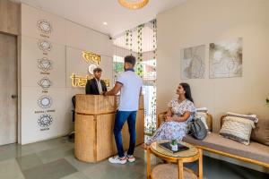 a man and a woman standing at a counter in a room at Hotel Tattva Suites NIBM, next to Corinthians Club in Pune