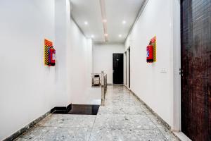 a hallway with white walls and paintings on the wall at Super Hotel O Panipat Railway Station Formerly Atithi in Pānīpat
