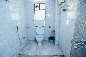 a bathroom with a toilet and a shower at Kalpataru Hometel in Mumbai