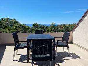 a blue table and chairs on a balcony at Apartmani Belobrk Potocnica Pag in Potocnica