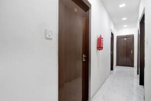 a hallway with a door and a red fire extinguisher at Super Collection O Park Street Metro Station Formerly Park Platinum in Kolkata
