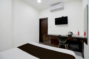 a hotel room with a desk and a bed and a chair at Super Collection O Park Street Metro Station Formerly Park Platinum in Kolkata