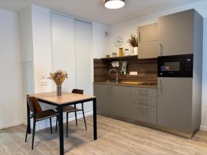 a kitchen with a table and a sink and a refrigerator at DOMITYS - Villa Caron - AEROPORT ORLY in Athis-Mons