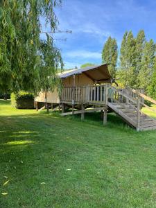 a wooden gazebo with a roof in a yard at Camping du pont d'Oust in Peillac