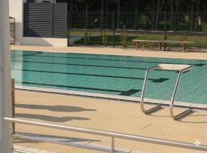 a chair sitting next to a swimming pool at Camping du pont d'Oust in Peillac