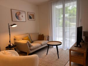 a living room with a couch and a table at DOMITYS - Villa Caron - AEROPORT ORLY in Athis-Mons