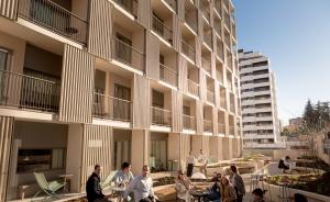 a group of people sitting at tables outside of a building at Kora Kiliki in Pamplona