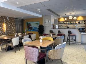 a restaurant with tables and chairs and a kitchen at DOMITYS - Villa Caron - AEROPORT ORLY in Athis-Mons