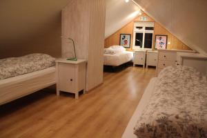a attic bedroom with two beds and wooden floors at RVK HoriZon in Álftanes