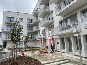 a building with chairs and tables in front of it at DOMITYS - Villa Caron - AEROPORT ORLY in Athis-Mons