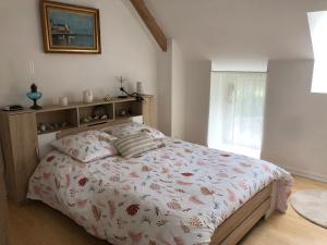 a bedroom with a bed with a floral bedspread at At Home in Cruguel