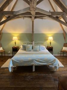 a bedroom with a large bed with two lamps at Manoir du Village in Irais +21 photos