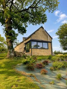 a brick house with large windows and a tree at At Home in Cruguel