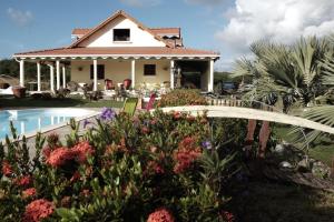 a house with a garden and a swimming pool at Bed and breakfast Riviere in Le Marin
