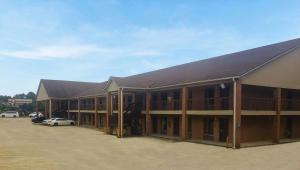 a row of buildings with cars parked in a parking lot at Magnuson Hotel Marietta in Marietta