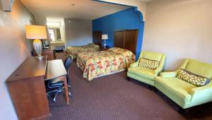 a hotel room with a bed and a desk and chairs at Magnuson Hotel Marietta in Marietta +7 photos