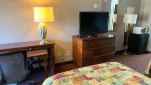 a hotel room with a television and a bed and a desk at Magnuson Hotel Marietta in Marietta
