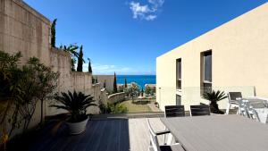 a balcony of a house with a table and chairs at MIKU Green Coast in Palasë