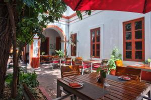 an outdoor patio with a table and chairs and an umbrella at Dune de L'orient in Pondicherry