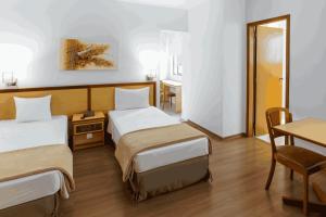 a hotel room with two beds and a table at Hotel Augusta Boulevard in São Paulo