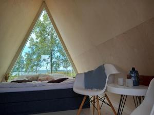 a bed and a chair in a room with a window at Glamping hut with panorama view in Björköby