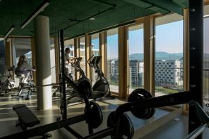 a gym with cardio equipment in a building with windows at Kora Kiliki in Pamplona