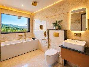 a bathroom with a tub and a toilet and a sink at Hotel The Montara Near Ganga Ghat in Rishīkesh