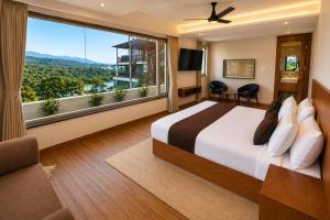a bedroom with a large bed and a large window at Hotel The Montara Near Ganga Ghat in Rishīkesh