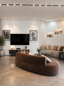 a living room with a large couch and a flat screen tv at Villa Gardenya וילה גרדניה אילת in Eilat