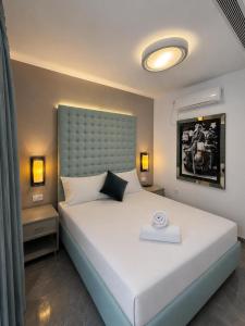 a bedroom with a large white bed with a large headboard at Villa Gardenya וילה גרדניה אילת in Eilat