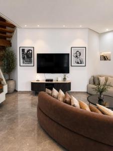 a living room with a couch and a flat screen tv at Villa Gardenya וילה גרדניה אילת in Eilat +32 photos