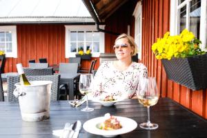 a woman sitting at a table with a plate of food at Glamping hut with panorama view in Björköby +31 photos
