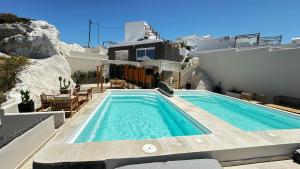 a swimming pool on the side of a house at Caldera Serenity - Small Luxury Villas in Imerovigli