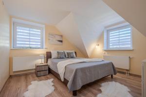 a bedroom with a bed and two windows at Leonardo Vila Centre in Palanga