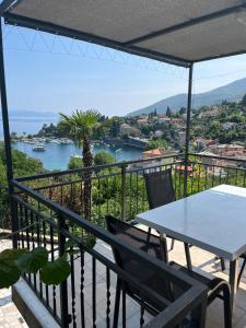 a table and chairs on a balcony with a view of the water at Apartments Branka in Ika
