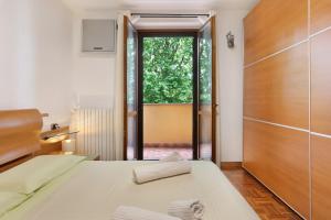a bedroom with two beds and a sliding glass door at Villa In Saronno in Saronno
