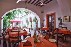 a dining room with tables and chairs and an archway at Dune de L'orient in Pondicherry