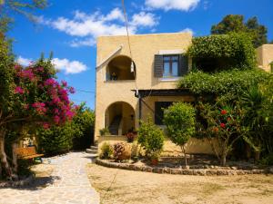 a house with flowers and plants in front of it at Billy's Place in Egina