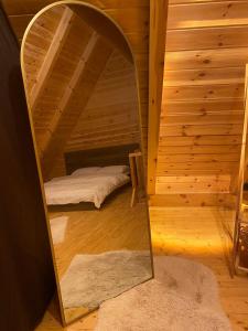 a mirror in a small room with a bed and a bed sqor at Doğa ile başbaşa dağ evi in Karadere