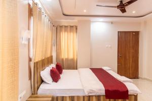 a bedroom with a large bed with red pillows at Raghuvansh Hotel in Gaya