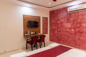 a bedroom with a bed and a table with two chairs at Raghuvansh Hotel in Gaya