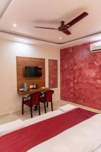 a bedroom with a bed and a desk with two chairs at Raghuvansh Hotel in Gaya