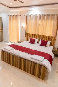a large bed with red pillows in a room at Raghuvansh Hotel in Gaya