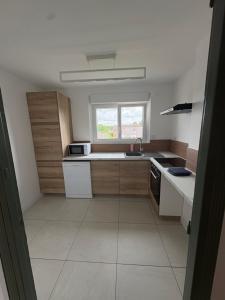 a small kitchen with white appliances and a window at Gambetta in Rethel