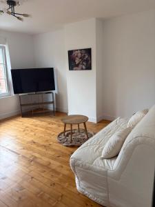 a living room with a couch and a flat screen tv at Gambetta in Rethel